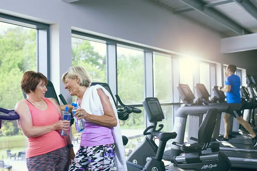 senior women in gym share a joke